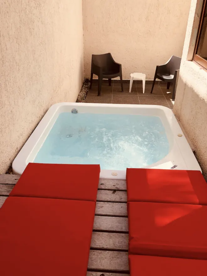 Private jacuzzi with crystal-clear water and red loungers on the terrace of Villa La Ceiba, Playa del Carmen