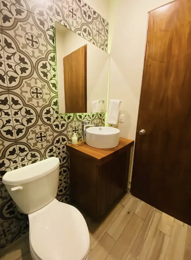 Full bathroom with black-and-white talavera tile and round sink at Villa La Ceiba
