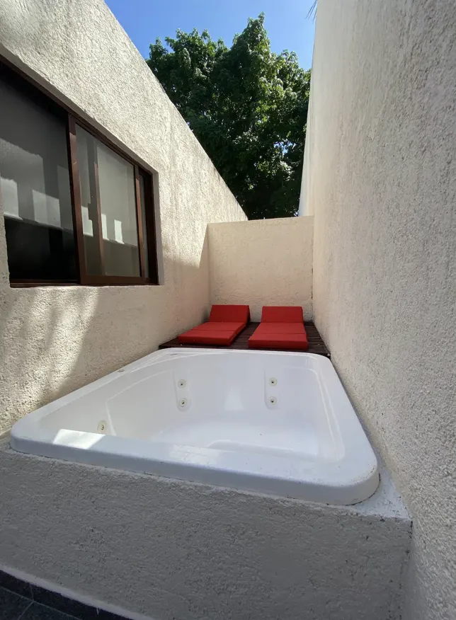 Open-air private jacuzzi with red loungers on the terrace of Villa La Ceiba, Playa del Carmen