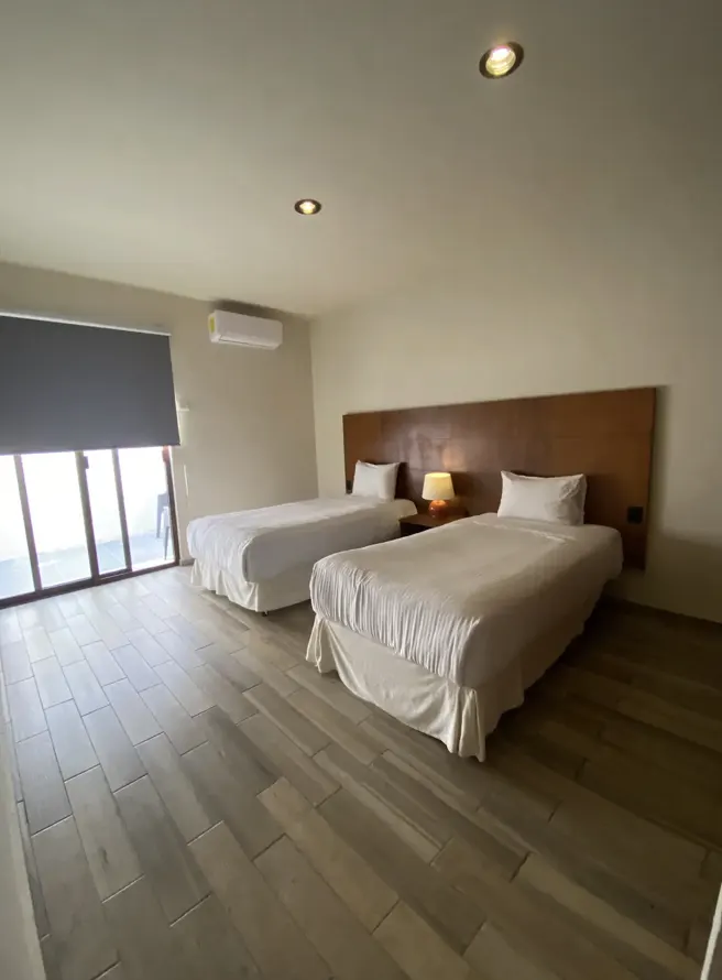 Second bedroom with two twin beds, picture window and air conditioning at Villa La Ceiba