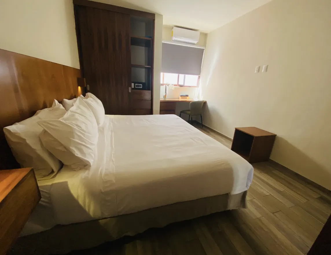 Master bedroom with King bed, wooden headboard, desk and A/C at Villa La Ceiba